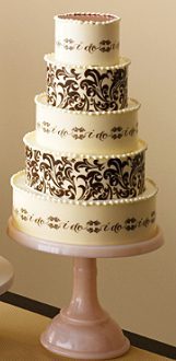 720 A white and brown wedding cake on a stand.