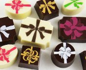 A group of chocolates with bows on them.