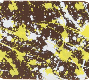 A SPLATTER coaster in yellow and white design, measuring 10" x 16".