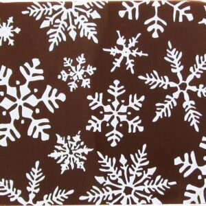 A brown and white snowflake coaster with white snowflakes.