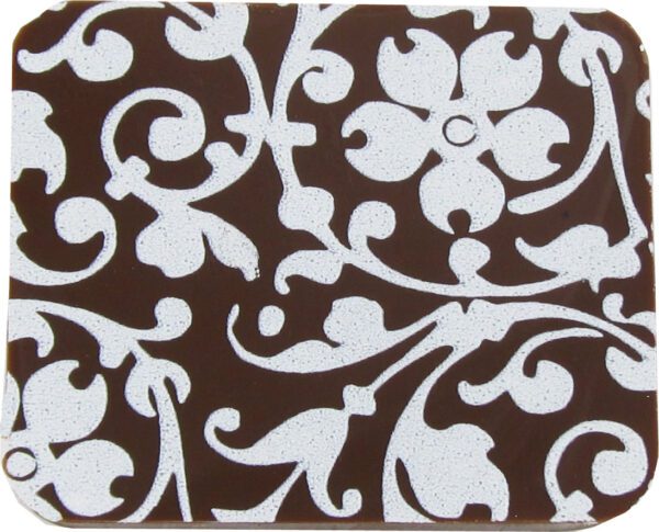 A brown and white coaster with a floral design.