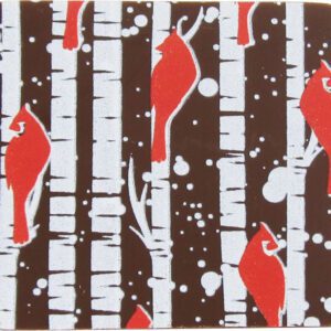 A brown coaster with red and white cardinals and birch trees.