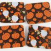 Four coasters with pumpkins and gnomes on them.