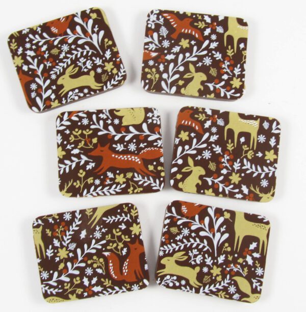 A set of brown and brown coasters with deer and flowers on them.