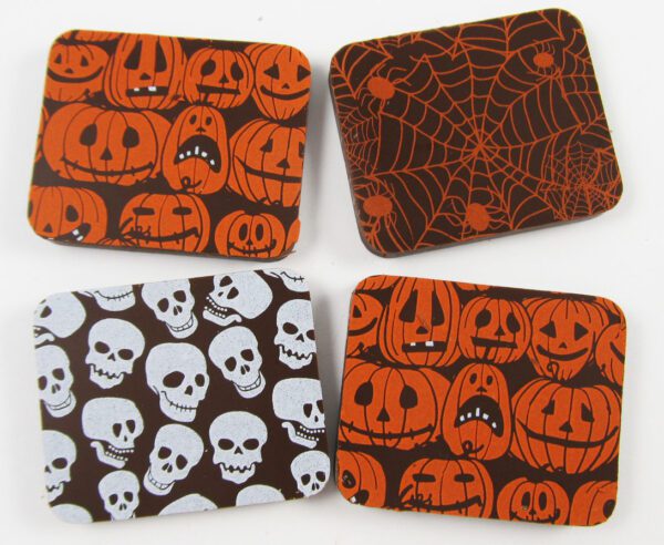 Four coasters with pumpkins and spiders on them.