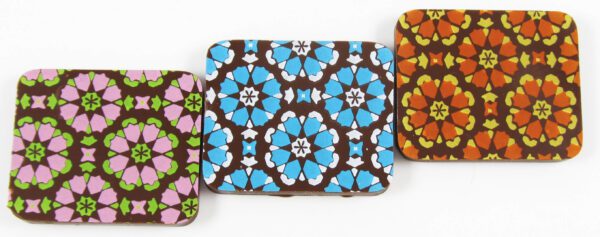 Three different colored and patterned chocolate bars on a white surface.