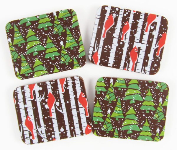 Four coasters with christmas trees and cardinals on them.