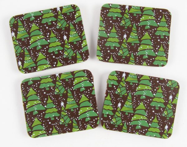 Four coasters with christmas trees on them.