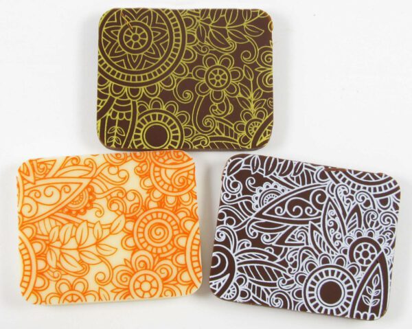 Three coasters with paisley designs on them.