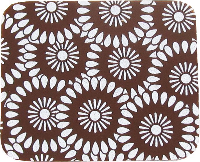 A brown and white coaster with flowers on it.